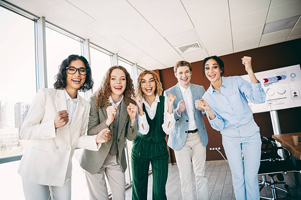 istock Diverse group of professionals celebrating teamwork success in modern office setting, highlighting collaboration and corporate spirit 2238291963