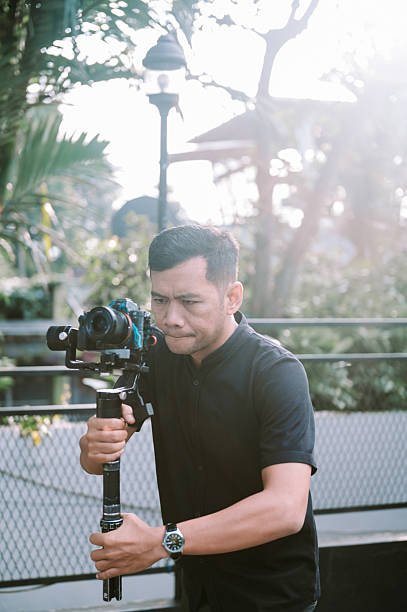 istock Man uses camera gimbal in outdoor setting 2238293076