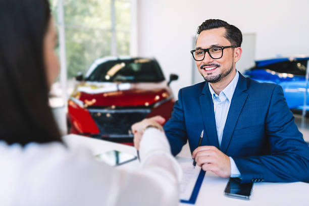 istock Car salesman explaining vehicle features to customer in showroom 2238293991