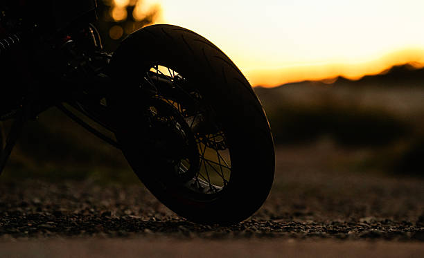 istock Motorcycle silhouette on gravel road at dusk.. 2238295446