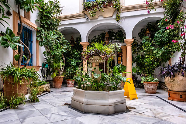 Flower pots hanging at the whitewashed walls in the tiny Plaza San Antonio in the Barrio La Villa, a charming district with set of cobbled narrow alleys and peaceful squares in Priego de Cordoba