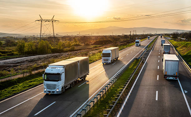 istock Big transportation trucks on a highway at sunset 2238297432
