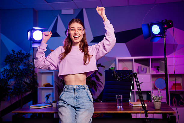 istock Young female blogger streaming in creative studio with professional equipment, vibrant lights, and expressive demeanor 2238299612