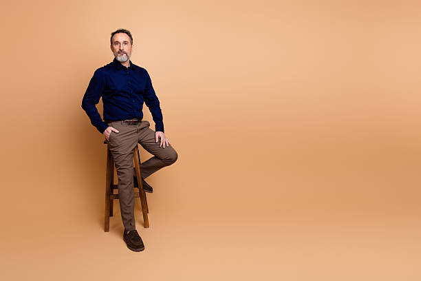 istock Professional male executive posing confidently against beige backdrop in formal attire emphasizing modern business style 2238300260