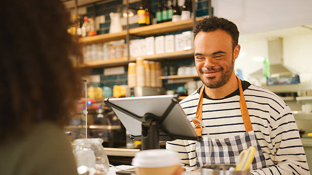 istock Man With Down Syndrome Serving Female Customer At Coffee Shop Checkout 2238302406
