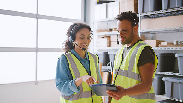 istock Man With Down Syndrome Using Digital Tablet With Female Colleague In Warehouse Wearing Headsets 2238302430