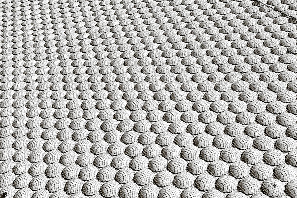 A black and white abstract background with a repeating geometric pattern of spheres covered in a grid texture. A modern, futuristic, and rhythmic architectural detail.