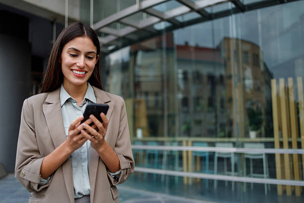 istock Professional businesswoman smiling while using smartphone for communication or business in urban setting 2238306515