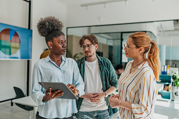 istock Young adults engaged in discussion while working in a modern office environment focused on teamwork and communication 2238306768