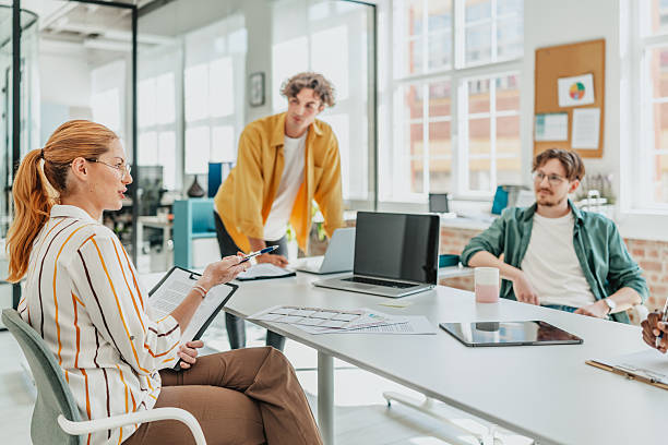 istock Young adults engaged in teamwork and discussion in a modern office workspace during a collaborative meeting 2238306912