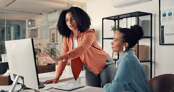 istock Creative, women and teamwork with computer, office and working late with market research and online. People, brand manager and collaboration with tech for strategy, pointing and ad campaign at night 2238308570