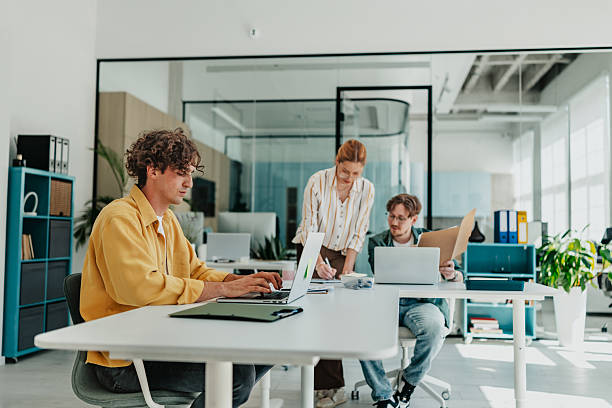 Young professionals collaborate in a modern office, engaging in teamwork and communication during work hours