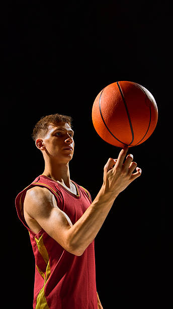 Basketball player spinning ball on finger with confidence and focus