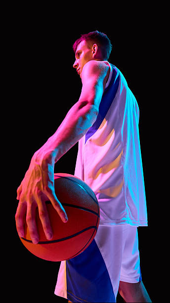 istock Basketball player holding ball in neon light with determination and strength 2238310405