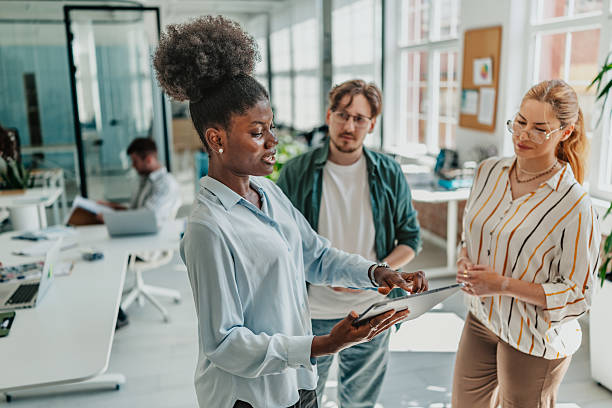 istock Young professionals engage in collaboration and discussion in a modern office setting with technology and teamwork 2238311329