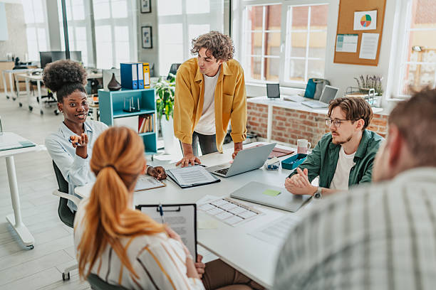 istock Young professionals engage in lively discussion at a modern office workspace in a collaborative meeting setting 2238311631
