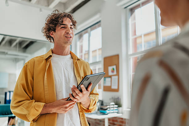 istock Young professionals engage in teamwork and communication at a modern office space during a productive workday 2238312353