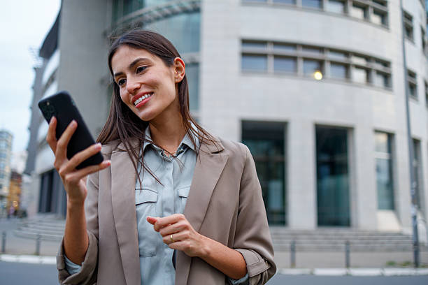 istock Smiling businesswoman navigating the urban environment, connecting with her device while on the move 2238312833