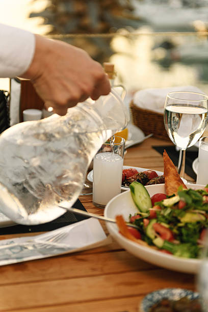 istock Waiter Adding Water to Raki Glass at Sunset 2238318348