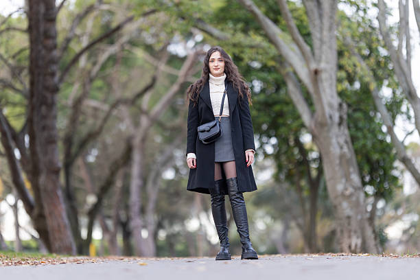 istock Young woman standing on path in park avenue 2238318791