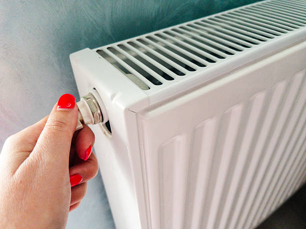 istock Hand adjusting radiator valve for home heating and energy saving 2238319031