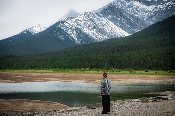 istock Woman contemplates nature at a lakeside 2238320266