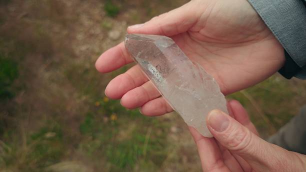 istock Man’s hands passing magical crystal to woman’s hands as she carefully examines it 2238321170