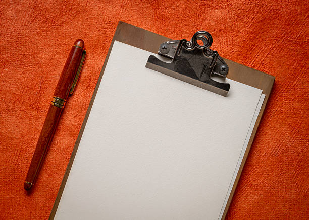 clipboard with a blank paper, desktop with a stylish pen