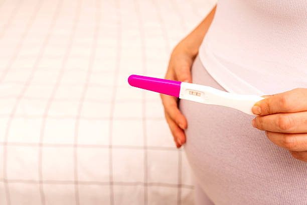 Positive pregnancy test on white background.
