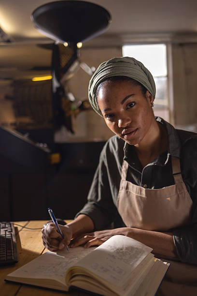 istock Focused Woman Writing in Notebook at a Wood Workbench in a Studio Workshop 2238334160