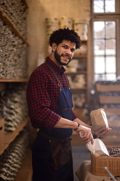 istock Friendly Barista In Apron Scooping Coffee Beans In Cozy Rustic Workshop Store Setting 2238334187