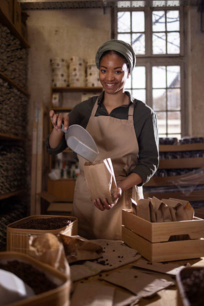 istock Smiling Woman In Apron Packs Coffee Beans In Rustic Workshop For Artisan Coffee 2238334196