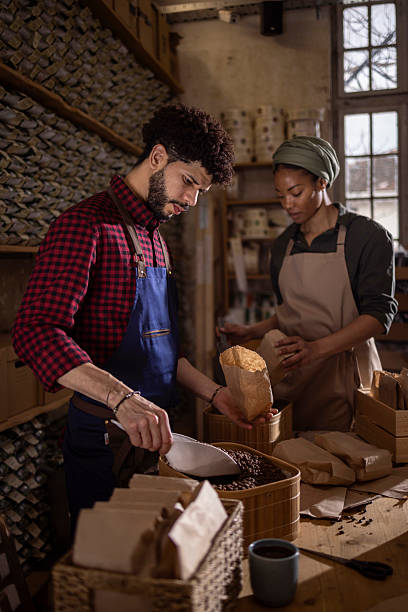 istock Two People Working Together in a Rustic Coffee Workshop Bagging Fresh Roasted Beans for Sale 2238334197