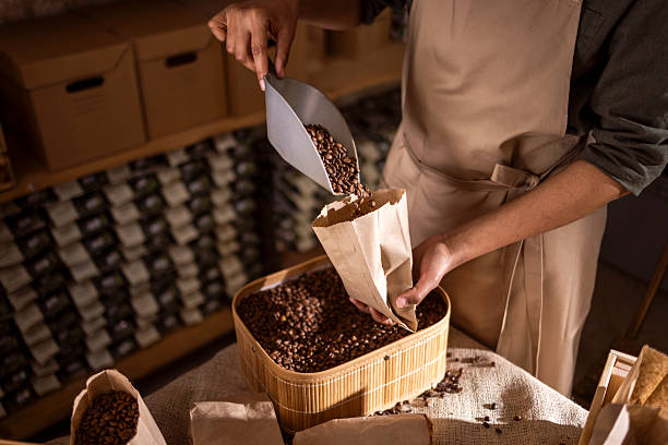 istock Barista Pouring Coffee Beans Into Paper Bag From Roasted Batch In Rustic Coffee Shop 2238334199