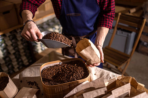 istock Barista Hands Scoop Roasted Coffee Beans Into Paper Bag In Rustic Workshop 2238334210