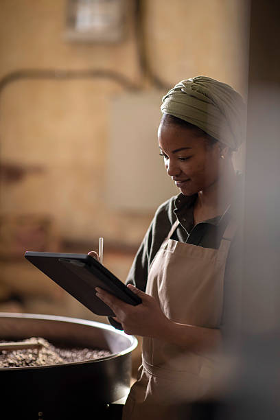 istock Young Woman Using a Tablet for Monitoring Coffee Roasting Process 2238334471