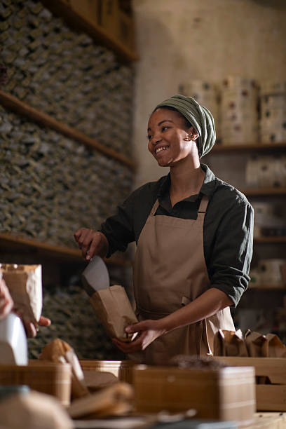 istock Smiling Worker Packaging Goods in Grocery Shop With Warm Lighting 2238334498
