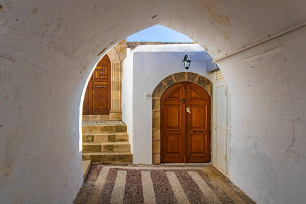 Beutiful wooden doors seen through a white archway, Lindos, Rhodes, Greece