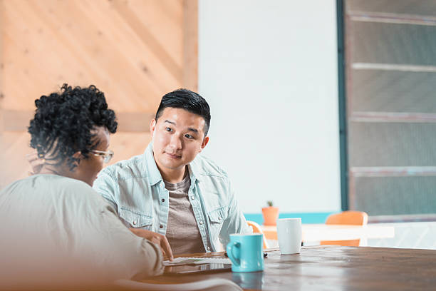 istock Diverse adults collaborate and communicate at a modern table with coffee mugs. 2238336936