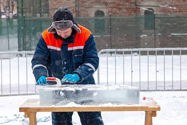 Vologda, Russia - February 15, 2025. Artists carve ice sculptures outdoors in a city square