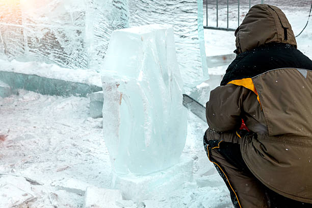 Vologda, Russia - February 15, 2025. Artists carve ice sculptures outdoors in a city square