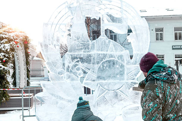 Vologda, Russia - February 15, 2025. Artists carve ice sculptures outdoors in a city square
