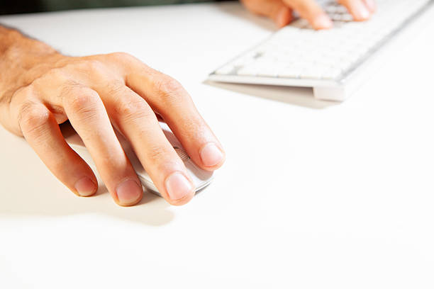 Closeup of man's hand typing on computer keyboard on white background