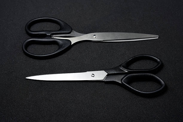 istock Two scissors on a black background. Stationery scissors. 2238348715