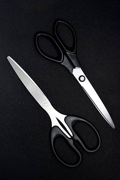 istock Two scissors on a black background. Stationery scissors. 2238348718