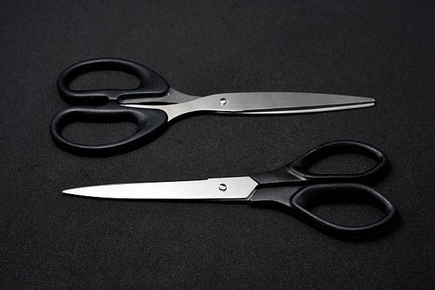 istock Two scissors on a black background. Stationery scissors. 2238348773