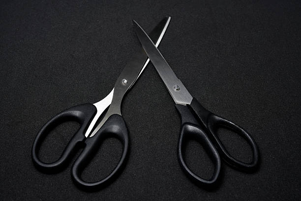 istock Two scissors on a black background. Stationery scissors. 2238348777