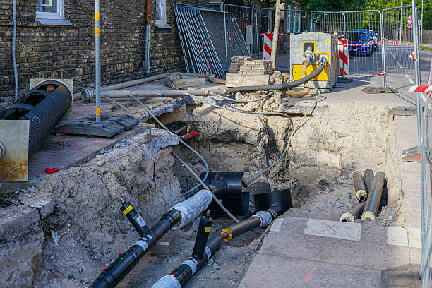 istock Dewatering pump draining construction pit during heating pipe replacement on urban street site 2238351053