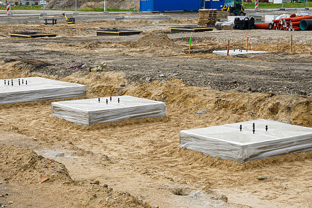 istock Concrete foundation blocks with anchor bolts at building construction site groundwork 2238351113