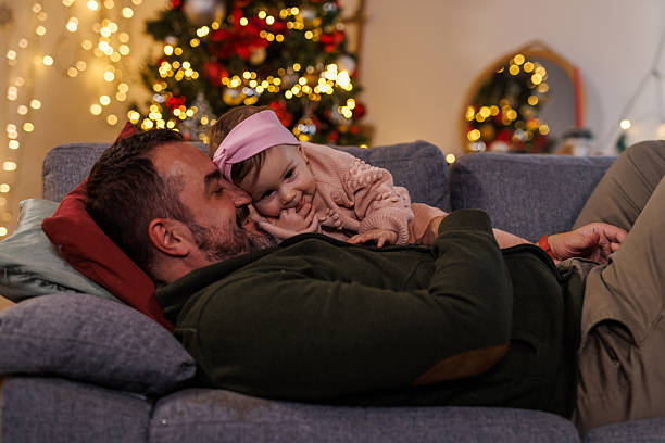 istock Man lying on the sofa, playing and cuddling with his baby daughter 2238353667